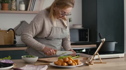 Woman Chopping Vegetables in Kitchen