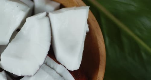 Coconut Chunks in a Bowl with Tropical Leaf