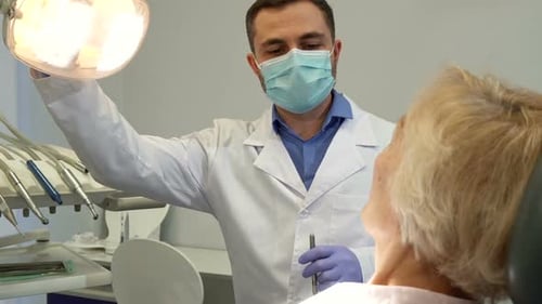 Dentist Examining Patient's Teeth in Bright Office