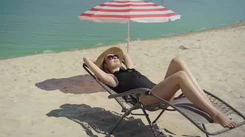 Woman Relaxes on Beach Lounge Chair in the Sun
