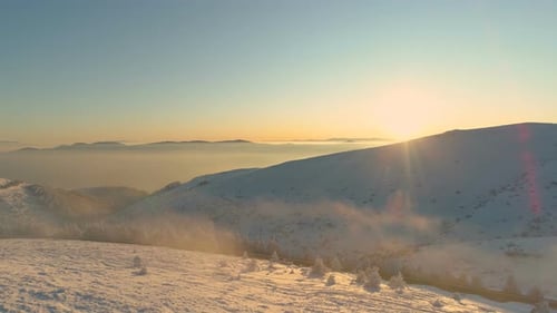 Sunrise at Misty Snowy Mountain Peaks in Serene Panoramic View