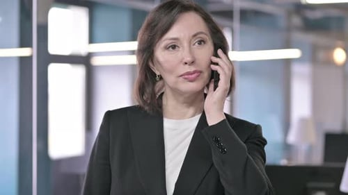 Professional Woman Talking on Smartphone in Office