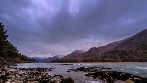 Time Lapse Shot of a River Near Mountain Forest. Huge Rocks and Fast Clouds Movenings.