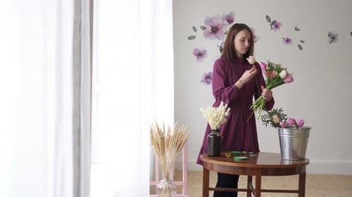 Une fleuriste fabrique un bouquet de fleurs dans un atelier