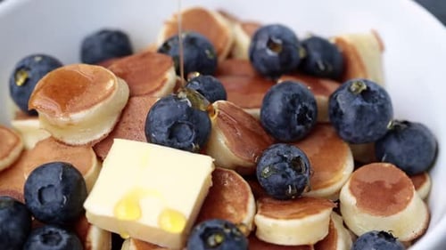 Pancake Cereal with Syrup, Butter and Berries in a White Bowl, Tiny Pancakes