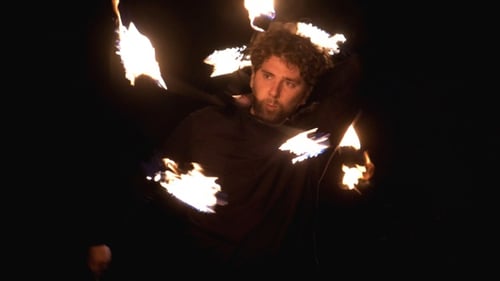 Man Juggling Fire Staff at Night
