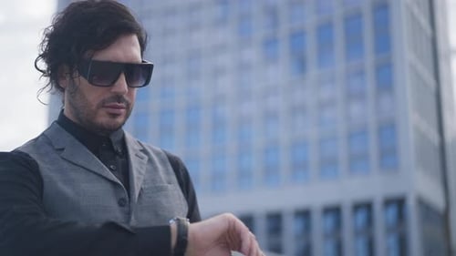Anxious Worried Young Businessman Checking Time on Watch Standing on City Street with Business