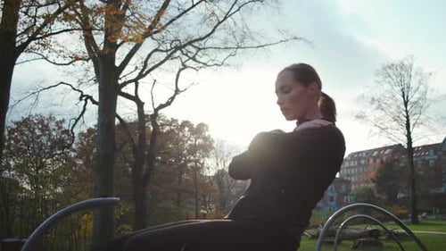Woman Doing Sit Ups in Urban Park