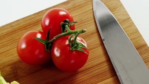 Fresh Tomatoes and Lettuce on Cutting Board