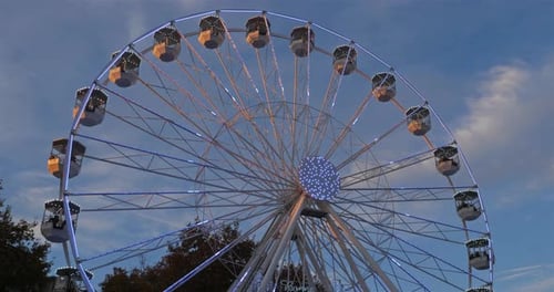 Riesenrad in Aktion vor blauem Himmel.