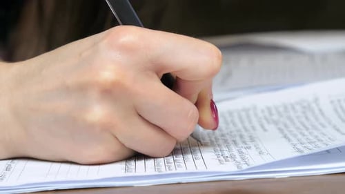 Hand Writes on Form or Contract Close Up