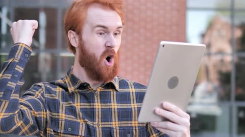 Excited Man Holding Tablet in Urban Setting