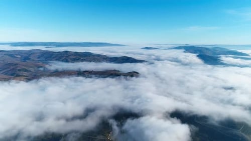 Flying Over Clouds and Mountains with Blue Sky