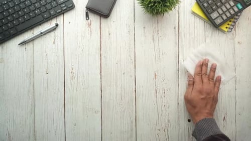 Junge Männer putzen einen Tisch mit einem Taschentuch