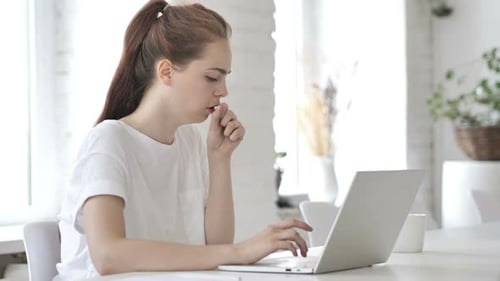 Woman Coughing While Using Laptop at Home