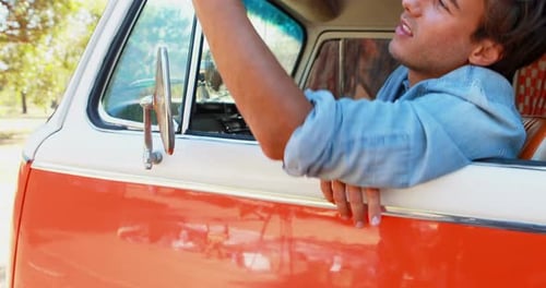 Young Adult Using Mobile Phone in Vintage Van
