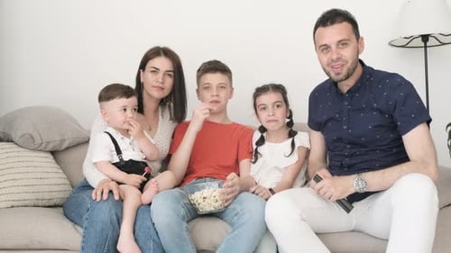Family Watching TV Together on Couch at Home