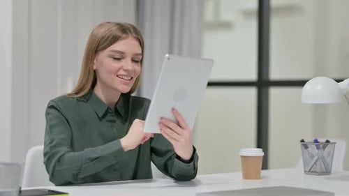 Young Woman Video Calling on Tablet at Desk