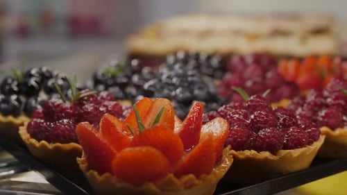 Side View Close Up of Fresh Berry Miniature Tarts in Bakery