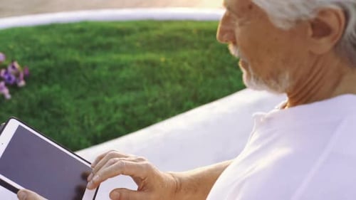 Portrait of Retirement Handsome Senior Man Using Tablet Computer on Seafront Close Up