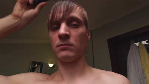 Young Adult Combs Wet Hair in Bathroom