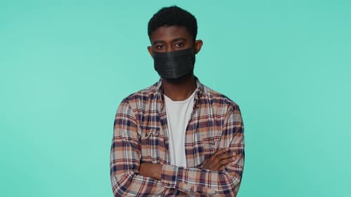Adult Puts on Protective Black Face Mask