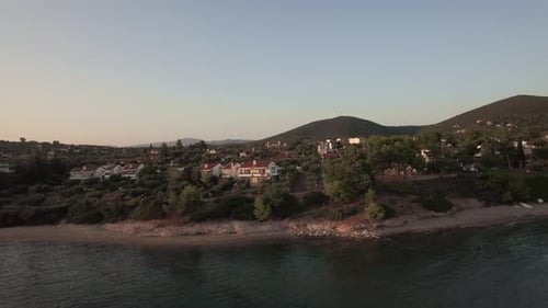 Aerial Scene of Trikorfo Beach Shore with Cottages and Green Hills, Greece