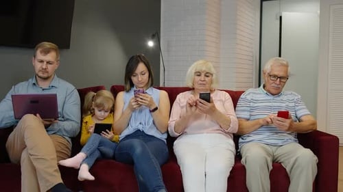 Family Using Technology Together on Couch Indoors