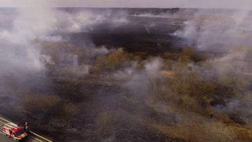 Wildfire Burns Across a Rural Field, Aerial View