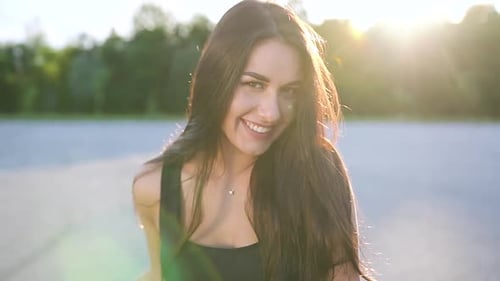 Young Woman Smiling on Motorcycle at Sunset