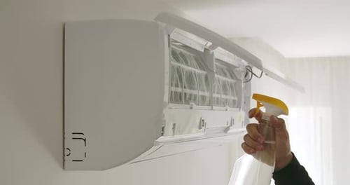 Spraying Cleaner into Air Conditioner in Home
