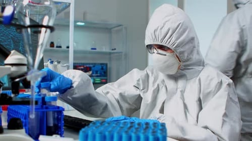 Forscher in der Gesamtprüfung von Flüssigkeitsproben mit Reagenzgläsern