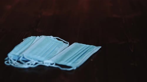 Stack of Disposable Surgical Masks on Brown Surface