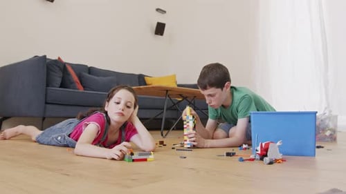 Boy and Girl Play with Toy Blocks at Home