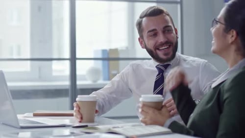 Business Partners Chatting over Coffee in Office