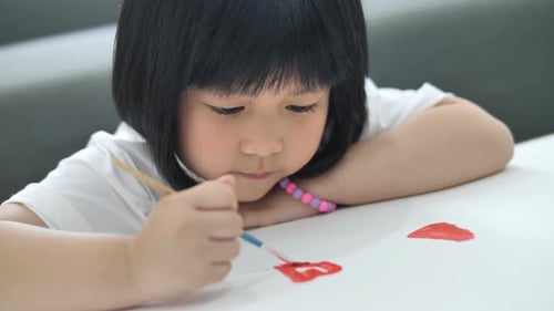 Happy Asian girl draw picture on paper, Happiness moment at home.