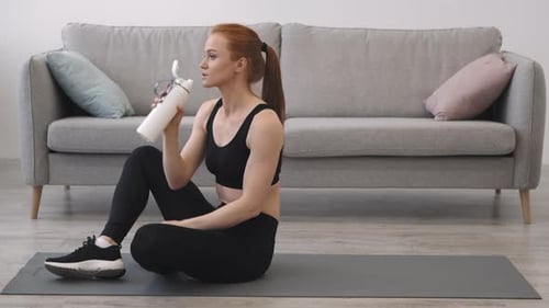 Athletic Woman Hydrating After Workout at Home