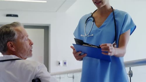 Doctor Discussing Report with Patient in Wheelchair