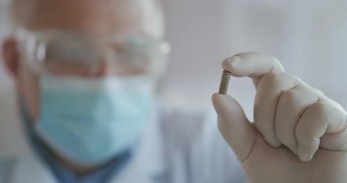 Extreme Close-up of Scientist in the Mask Developer of the Vaccine Against Coronavirus Holds in His