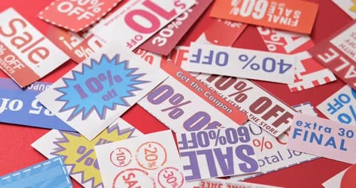 Sale and Discount Coupons Falling on Red Surface