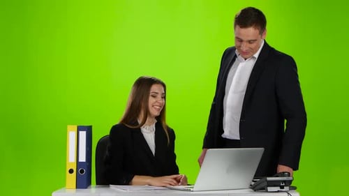 Two Office Workers Laughing at What He Saw on Laptop