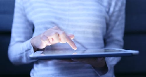 Woman use of tablet computer at night