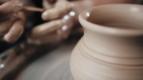 Man Potter Working on Potters Wheel Making Ceramic Pot From Clay in Pottery Workshop