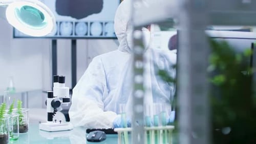 Scientist in Hazmat Suit Works in Bright Laboratory