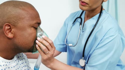 Healthcare Worker Assists Patient with Oxygen Mask