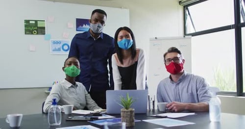 Portrait of office colleagues wearing face masks in meeting room at modern office