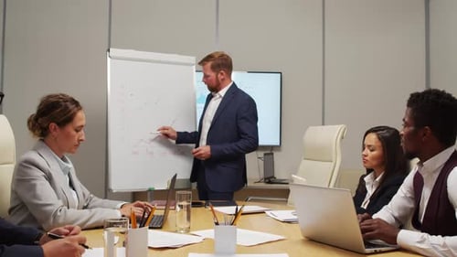 Businessman Delivering Financial Report to Colleagues