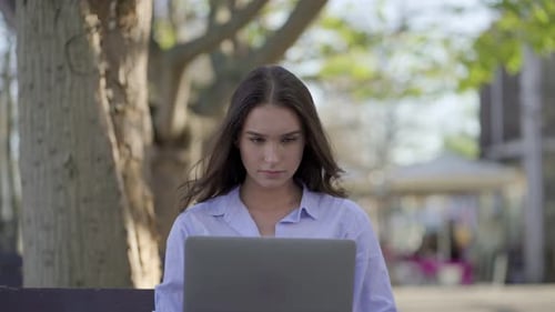 Medium Shot of Pretty Caucasian Woman in Park Working on Laptop