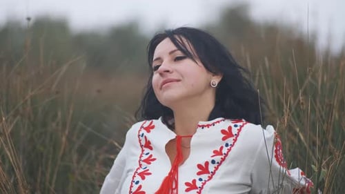 Portrait of Cheerful Charming Young Ukrainian Woman in National Clothes in Field