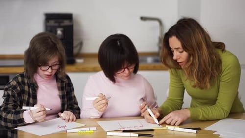 Woman Helping Two Girls Drawing with Markers